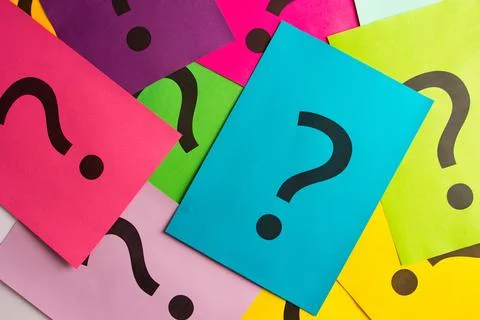 Black question marks on the colored papers Stock Photos