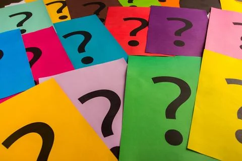 Black question marks on the colored papers Stockfoto's