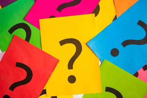 Black question marks on the colored papers 스톡 사진