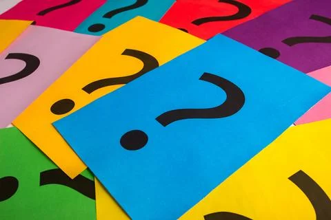 Black question marks on the colored papers Stockfoto's