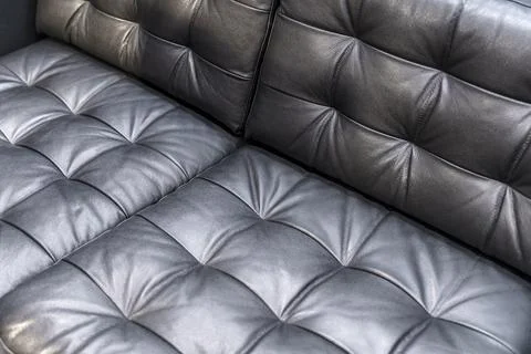 Black Quilted Leather Sofa Corner Close Up with Soft Cushioned Texture Details Stock Photos