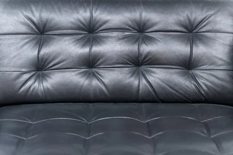 Black Quilted Leather Sofa Corner Close Up with Soft Cushioned Texture Details Stock Photos