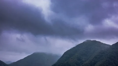 Black rain clouds are dramatically passing over the mountains. Time lapse Stock Footage 145864206