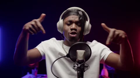 Black rapper in headphones performs self-written rap song in well-equipped Stock Footage 243519243