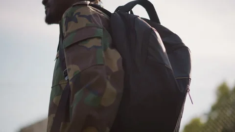 Black Recruit Walking With Heavy Backpack Past Fence, Camouflage Jacket And Stock Footage 324758275