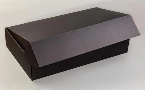 Black rectangular cardboard box with slightly open lid Stock Photos