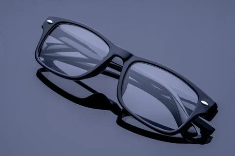 Black rectangular glasses on a black mirrored background studio shooting gl.. Stock Photos