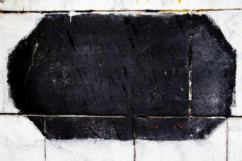 Black rectangular hexagon on a white tiled wall surface. Foto stock