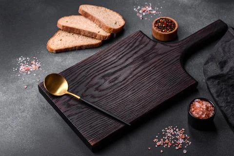 Black rectangular wooden cutting board with salt and spices Stock Photos