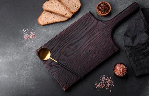 Black rectangular wooden cutting board with salt and spices Stock Photos