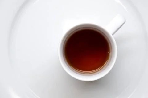 Black refreshing tea and a white mug in a table Black refreshing and energ... Stock Photos