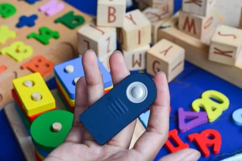 Black remote control resting on a white surface with buttons in focus. Stock Photos