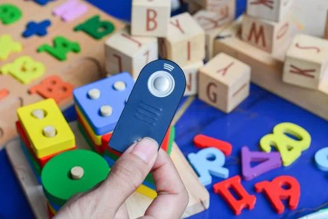 Black remote control resting on a white surface with buttons in focus. Stock Photos