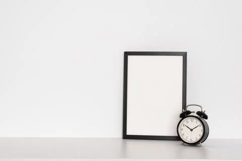 Black retro watch next to an empty frame on a white background. Minimalism. Stock Photos