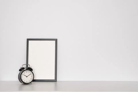 Black retro watch next to an empty frame on a white background. Minimalism. Stock Photos