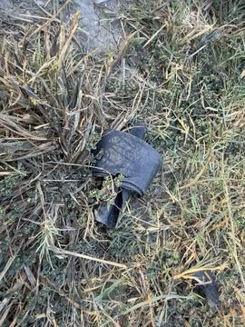 Black Ribbed Plastic Object on Dry Patchy Grass Stock Photos