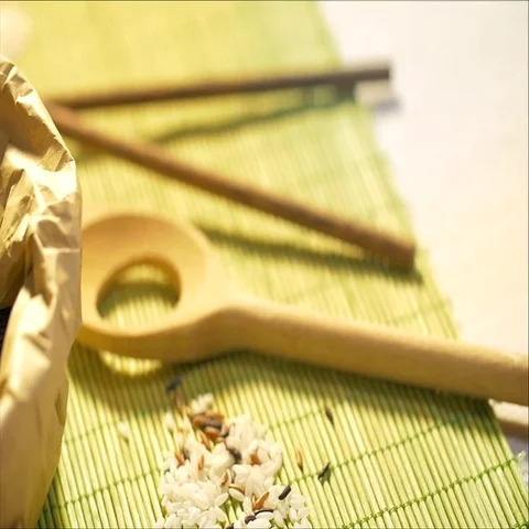 Black rice grains dropping down into a paper food bag. Stock Footage 69709401