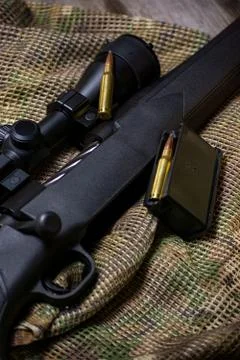The Black Rifle with ammo and scope on the multicam background. Close up. Stock Photos
