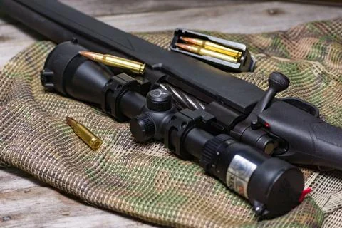 The Black Rifle with ammo and scope on the multicam background. Close up. Stock Photos