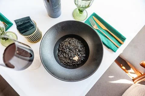 Black risotto on a black plate isolated Foto stock