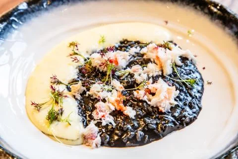 Black risotto with cuttlefish ink and crabs Stock Photos
