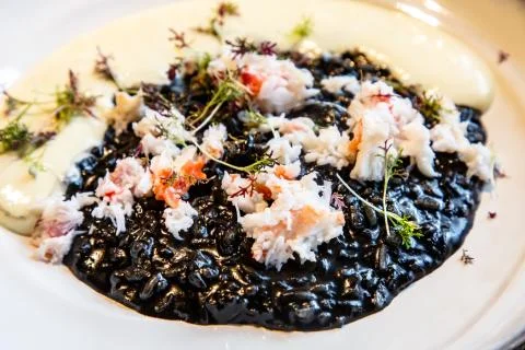 Black risotto with cuttlefish ink and crabs Stock Photos