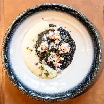 Black risotto with cuttlefish ink and crabs Stock Photos