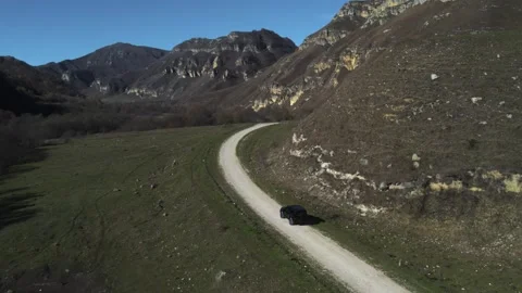  A black off-road vehicle travels through incredibly beautiful mountains.  Stock Footage 290396053