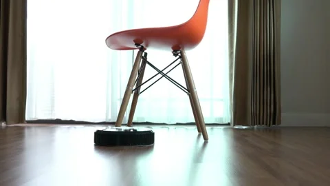 A black robot is cleaning a white floor. Home automation Stock Footage 313357046