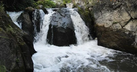 Black rock. A mountain river running among the stones forms a stormy waterfall Stock-Footage 205073593