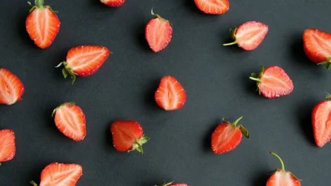 Black rotating background with strawberry halves, top view Stock Footage 133191657