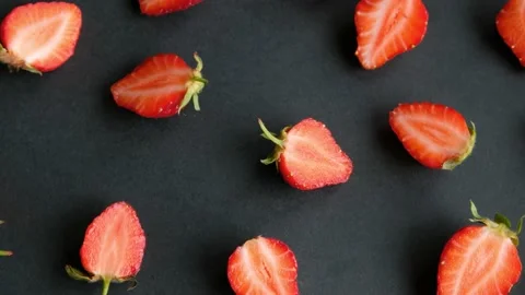 Black rotating background with strawberry halves, top view Stock Footage 138806050