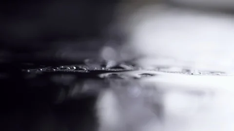 On black rotating a background water drops lie. Patches of light from water Stock Footage 87405660