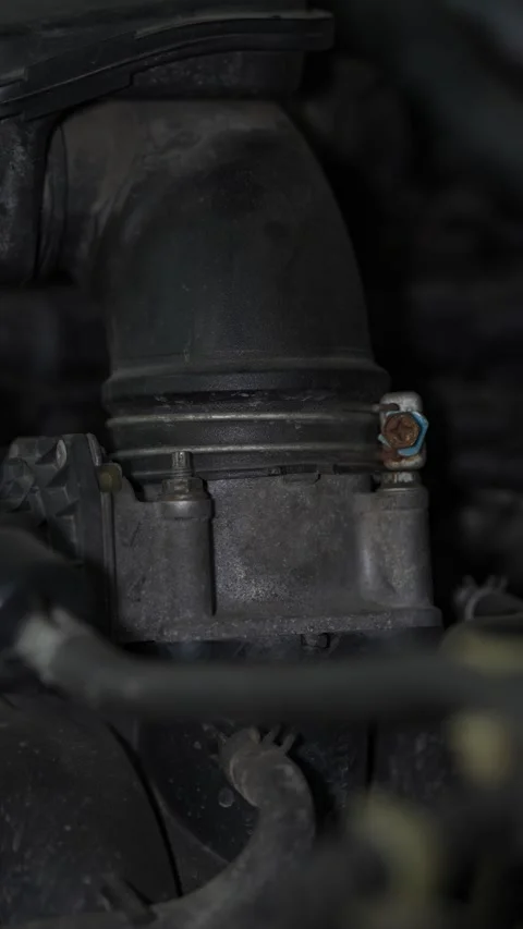 A black rubber air intake hose connected to a metal throttle Stock Footage 343552552