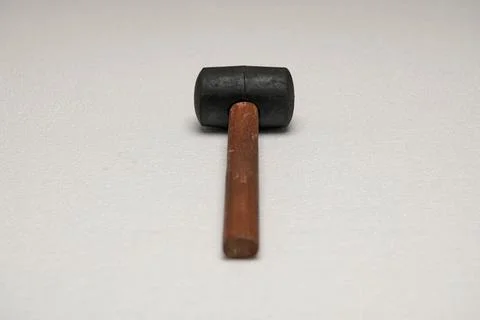 Black rubber mallet on gray surface Stock Photos