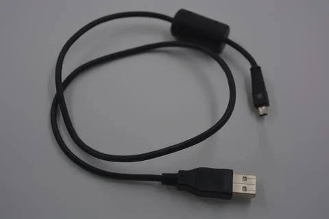 Black rubber, plastic usb cable and micro usb are on a white plastic. Stock Photos