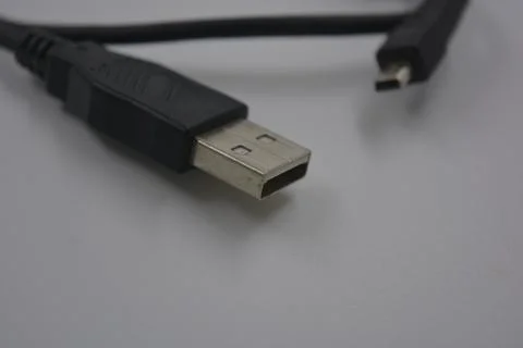 Black rubber, plastic usb cable and micro usb are on a white plastic. Stock Photos