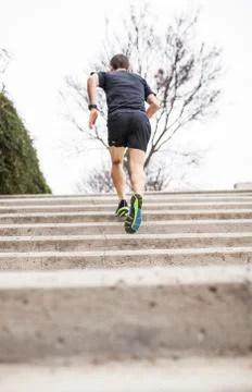 Black runner climbs stairs from the back Stock Photos