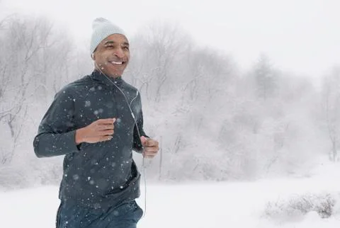 Black runner jogging in snow Foto stock