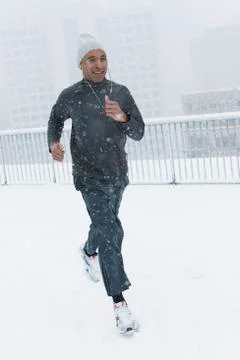 Black runner jogging in snow 스톡 사진