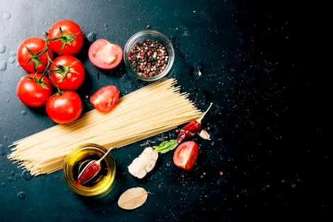 Black rustic tabletop with branch of tomatoes and herbs, top view Stockfoto's