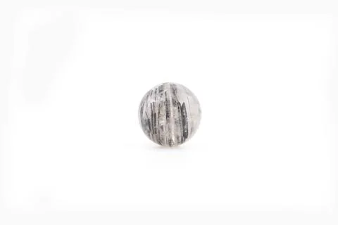 Black rutilated quartz stone placed on a plain background Stock Photos