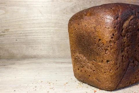 Black rye bread on wooden background. Stock Photos