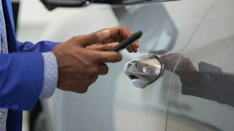 Black salesman opens car using app on mobile phone Stock Footage 220906253
