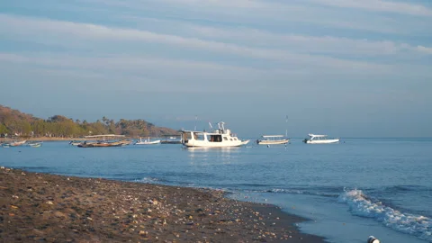 Black sand beach and small white boats in sea Stock-Footage 98656205