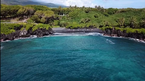 Black sand beach Hana Maui Hawaii Waianapanapa aerial drone pullout Stock Footage