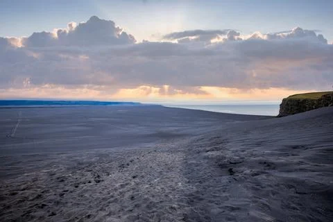 Black sand beach at sunset with dramatic clouds and sun rays in Iceland Foto stock