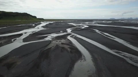 Black sand with streams running through it aerial Video stock 167335427