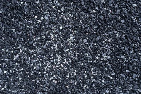 Black sand texture. Full frame macro photography of dark rough sand surface. Stock Photos