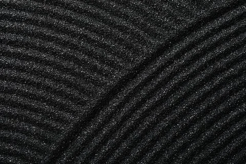 Black sand texture with wavy lines and diagonal patterns, minimalist zen gard Stock Photos